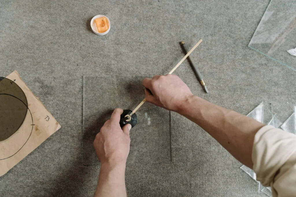 Glass being cut to size by hand on a workbench