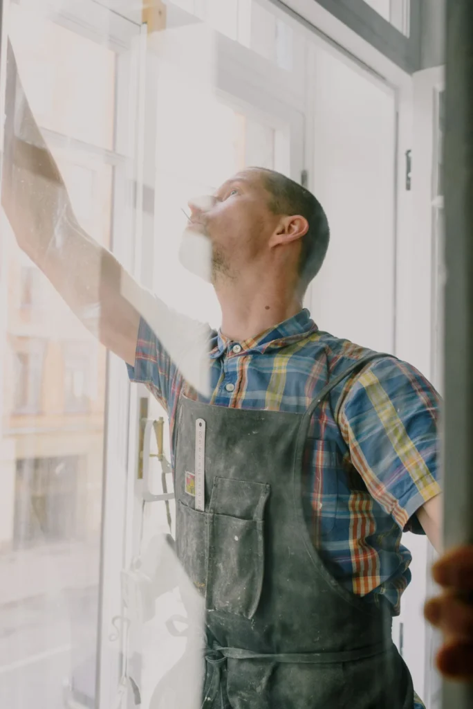 Glass technician fitting a new window pane in a bright home
